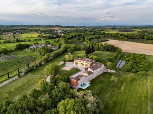 Aerial view of Corte Baruzzo Relais, a luxury Italian villa hotel in Volta Mantovana surrounded by green countryside