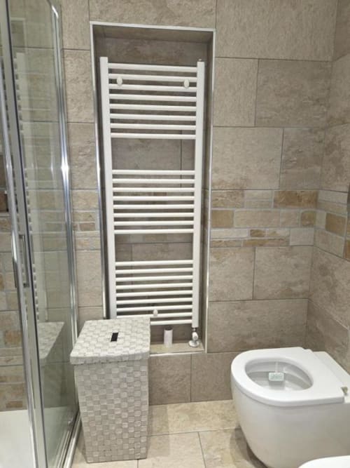 Bagno moderno dell'appartamento Mia Experience a Monza con scaldasalviette bianco, wc e zona doccia piastrellata
