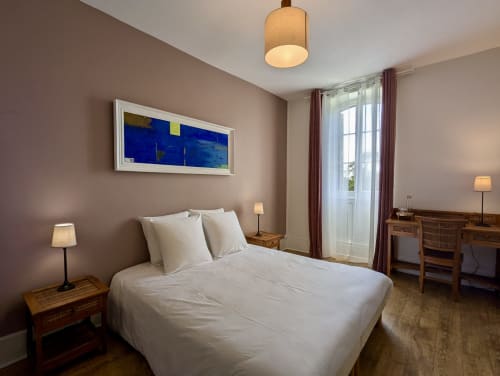 Suite Les Clos bedroom at Domaine du Faure B&B in Chadurie with queen bed, garden view, and modern amenities
