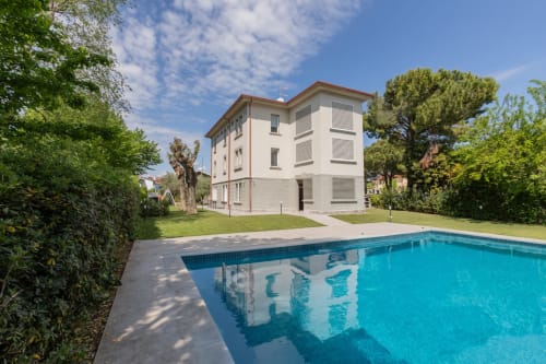 Hotel Prince Garda a Serniga con piscina, edificio moderno di bianco e ampi spazi verdi lussureggianti