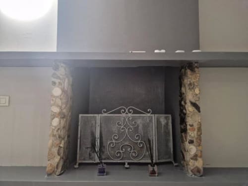 Schermo decorativo per camino con raffinati motivi a voluta e colonne in pietra nella Suite Casa Mia Vacanza Milano