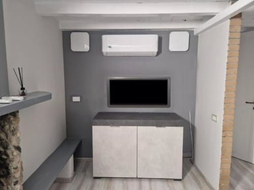 Angolo cottura moderno con TV a schermo piatto, climatizzatore e armadi in Casa Mia Vacanza Milano Suite
