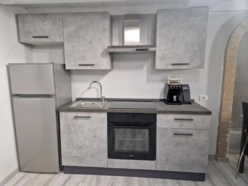 Cucina moderna della Milano Suite presso Casa Mia Vacanza con elettrodomestici in acciaio inox e mobili in stile cemento