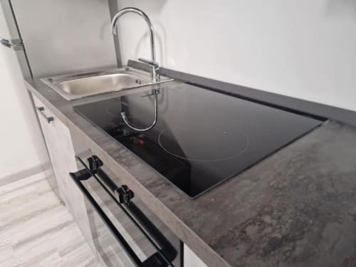 Cucina moderna con piano cottura a induzione, lavello in acciaio inox e rubinetto cromato nella Suite Casa Mia Vacanza Milano