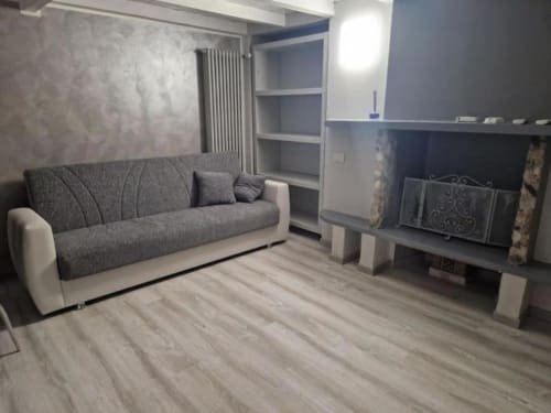 Soggiorno moderno con divano grigio, mobile TV e scaffalature integrate nell'appartamento Casa Mia Vacanza Milano Suite in Italia