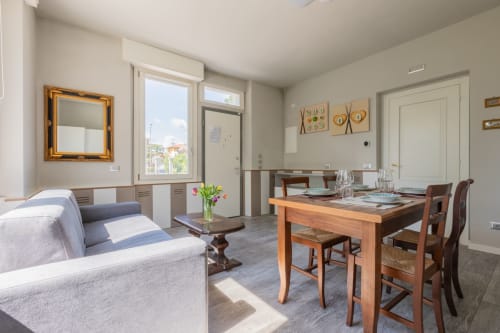 Studio moderno con tavolo in legno, zona living e vista sulla città presso Prince Garda, Serniga