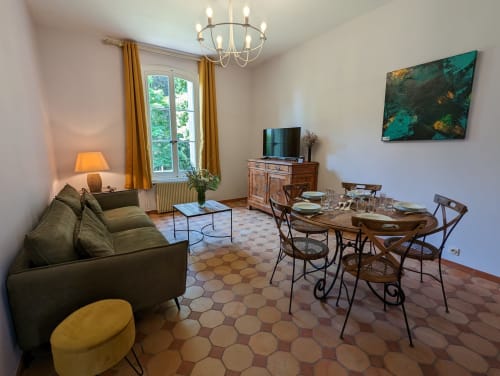 Spacieux séjour et salle à manger du Gîte Le Chêne au Domaine du Faure avec canapé, table de salle à manger et vue sur le jardin