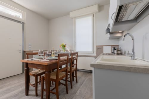 Moderna cucina e sala da pranzo dell'hotel Prince Garda a Serniga con tavolo in legno e elettrodomestici contemporanei