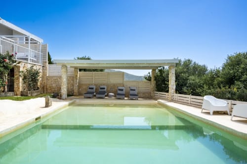 Luxury villa pool in Quartu Sant'Elena, Sardinia with sunbeds, pergola, and mountain views