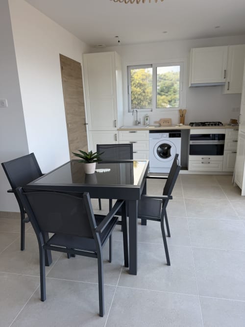 Cuisine-séjour moderne de l'appartement L'écrin de Paradis au Petit Coin de Paradis, Alata, avec table noire et vue mer