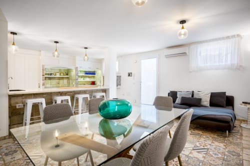 Modern open-plan villa interior in Quartu Sant'Elena with dining area, kitchen, and bedroom seating