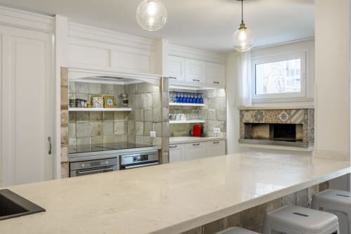 Modern kitchen with marble countertop, white cabinetry, and tiled backsplash at Top Villas Sardinia