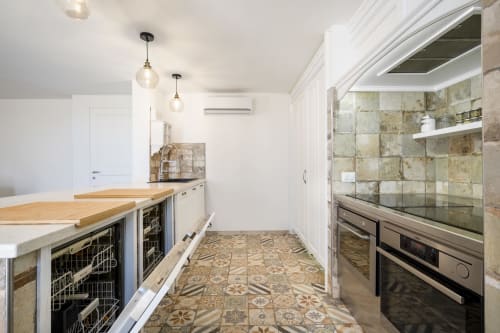 Modern kitchen in Top Villas Sardinia with wooden counters, marble backsplash, and patterned tile floors in Quartu