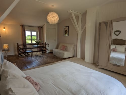 Chambre spacieuse au gîte Domaine du Faure à Chadurie avec vue sur jardin, mobilier élégant et lumière naturelle abondante