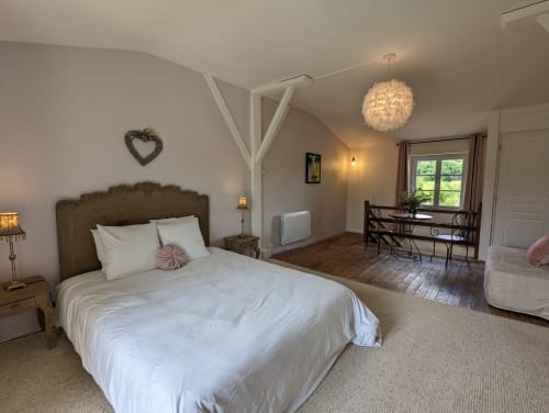 Chambre spacieuse du gîte Domaine du Faure avec vue sur le jardin, lit queen-size, bureau et équipements modernes