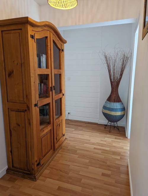 Chambre de cottage au Domaine du Faure avec armoire en bois, parquets et vase tressé décoratif sur pied métallique