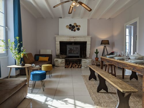 Vaste séjour du Domaine du Faure avec cheminée, table à manger et vue sur le jardin par de grandes fenêtres
