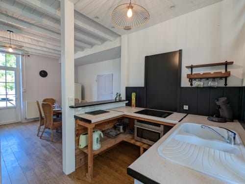 Cuisine et salle à manger modernes au Gîte Le Bambou du Domaine du Faure, Chadurie, avec mobilier en bois et vue sur le jardin