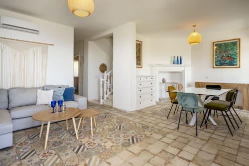 Modern villa living area in Quartu Sant'Elena with sofa, dining table, and kitchen in open-plan layout