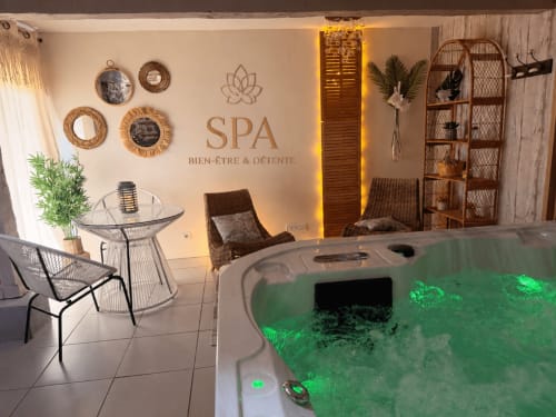 Spa luxueux aux Instants Volés avec jacuzzi vert luminescent, mobilier contemporain et décor zen à Tudeils, France
