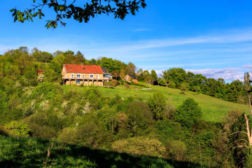 Charmante maison en pierre aux tuiles rouges, nichée sur une colline verdoyante à Les Instants Volés, retraite à la campagne