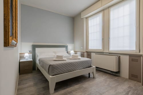 Camera moderna dell'hotel Prince Garda a Serniga con letto, comodini e ampie finestre