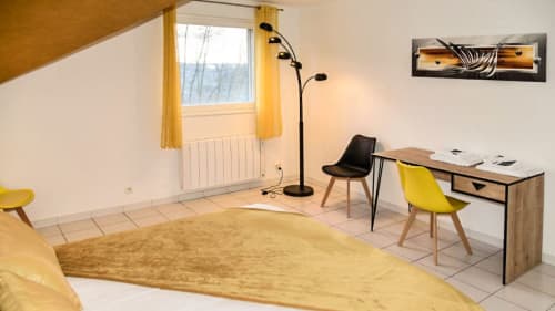 Modernes Schlafzimmer in der Villa Pré d'Oro mit gelben Akzenten, Schreibtisch, Heizkörper und Bergblick