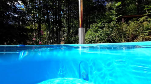 Kristallklarer blauer Swimmingpool umgeben von üppigem Wald in der Villa Pré d'Oro, Amage Frankreich