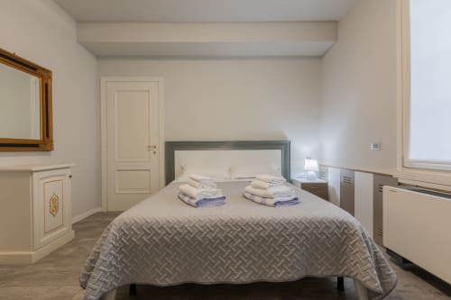 Camera moderna presso l'hotel Prince Garda a Serniga con letto matrimoniale, testata grigia e arredamento neutro