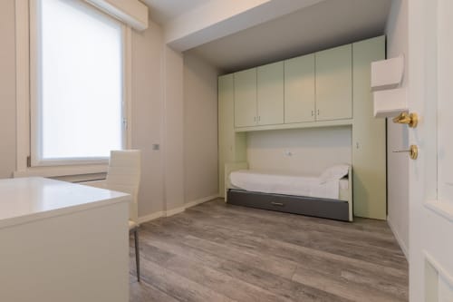 Camera moderna dell'hotel Prince Garda a Serniga con armadio integrato, letto e pavimento in legno
