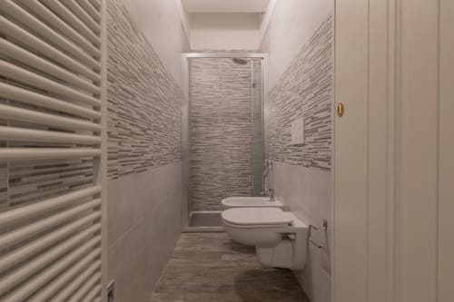 Bagno moderno dell'hotel Prince Garda a Serniga con piastrelle a righe, cabina doccia e finiture