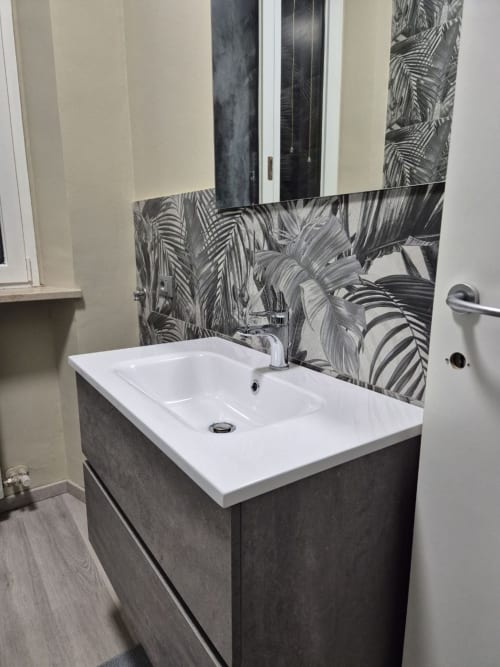Lavabo moderno con rivestimento a foglie di palma nere nell'appartamento Mia Experience di Monza