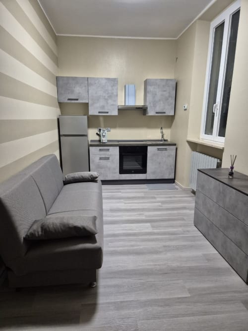 Moderno appartamento Mia Experience Monza con cucina a vista, zona living, divano e parete con righe
