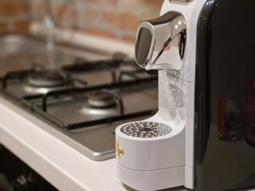 Macchina Nespresso bianca sul piano della cucina della suite Mia Monza a Monza, Italia
