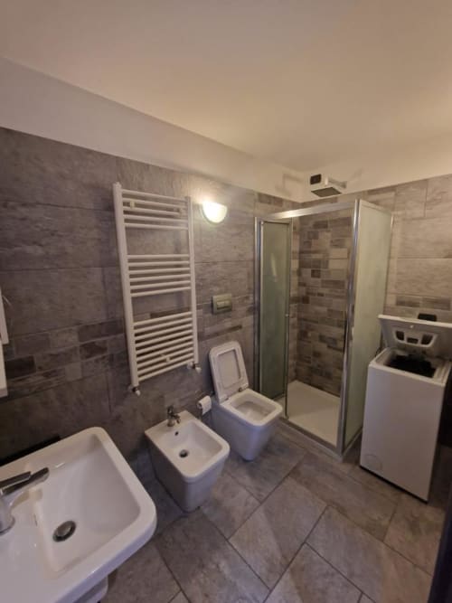 Bagno moderno nella suite Mia Monza con doccia, WC, bidet, lavabo e scaldasalviette