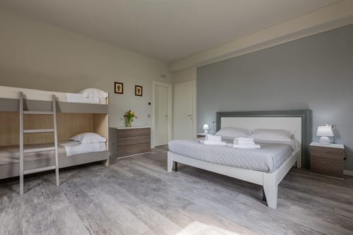 Suite ospiti moderna al Prince Garda Hotel di Serniga con letto matrimoniale, letti a castello e arredamento contemporaneo