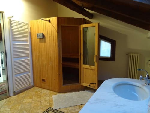 Sauna in legno e vasca idromassaggio nel bagno della Suite Familiare Alba Deluxe presso Mia Experience BnB, Monza, Italia