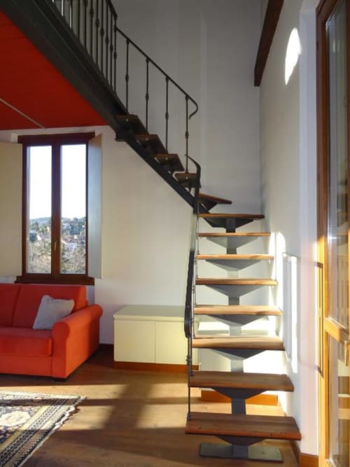 Scalone moderno nella Alba Deluxe Suite del Mia Experience B&B Monza, con parete d'accento rossa e vista sul giardino attraverso le finestre