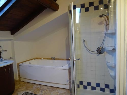 Bagno moderno nella Suite Alba Deluxe di Mia Experience a Monza, con vasca bianca e doccia con piastrelle blu