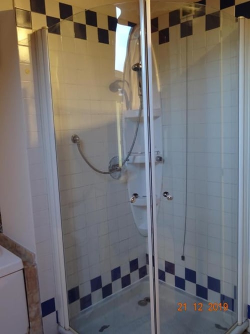 Moderna cabina doccia in vetro con dettagli di piastrelle a diamante bianco e nero presso Mia Experience B&B a Monza