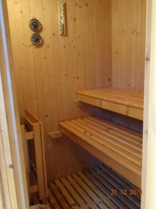 Interno di sauna in legno presso Mia Experience B&B a Monza con panche a gradinate e termometri sulla parete