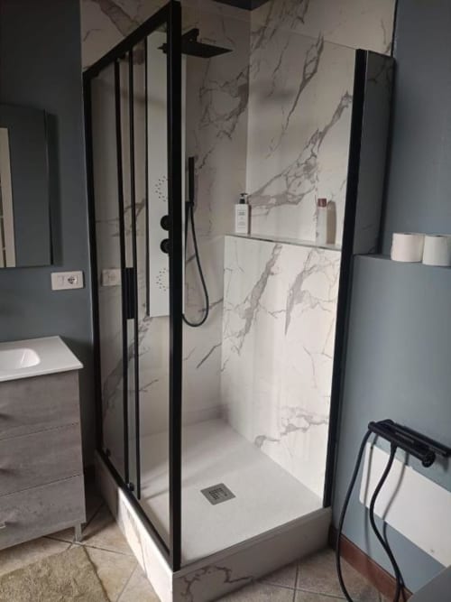 Moderna cabina doccia con cornice nera e rivestimenti in marmo nella Luna Deluxe Room di Mia Experience, Monza