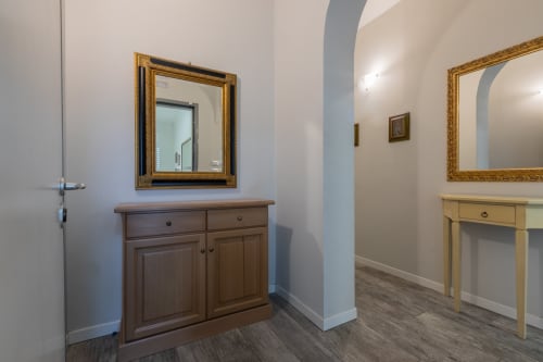 Elegante corridoio dell'hotel Prince Garda a Serniga con mobili in legno, specchi incorniciati e illuminazione moderna