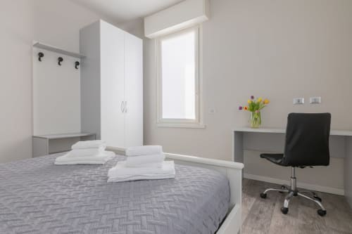 Camera moderna dell'hotel Prince Garda a Serniga con letto, guardaroba, scrivania e luce naturale