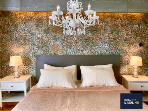 Camera lussuosa dell'Hotel Il Mulino con parete decorata di paillettes, lampadario, comodini bianchi e biancheria pregiata
