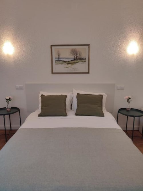 Quarto moderno no hotel Porta 80 House em Braga com cama queen, almofadas verde-azeite e decoração minimalista
