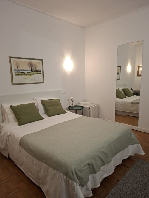 Porta 80 House Braga: Quarto Duplo Deluxe bedroom with queen bed, green cushions, mirror, and artwork