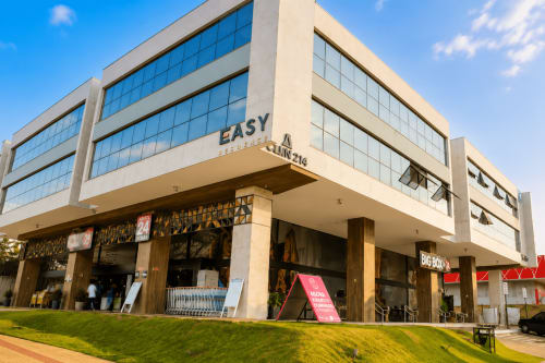 Edifício EASY Residences em Brasília com arquitetura moderna, janelas de vidro e entrada comercial no térreo para apartamentos