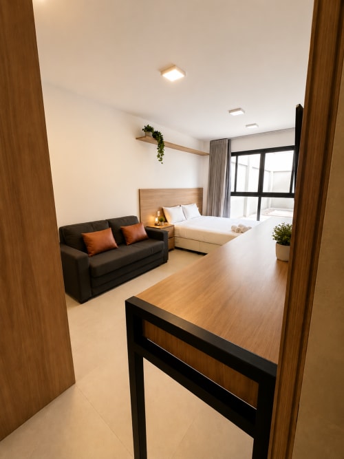 Quarto moderno em apartamento de Brasília com sofá preto, cama queen, acabamentos em madeira e vista do marco de chão ao teto