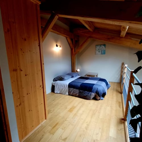 Chambre rustique aux poutres en bois et literie à carreaux bleus aux Gîtes Du Couvent, Ardèche